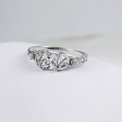 Anillo con diseño de nudo y piedra preciosa plateada en el centro