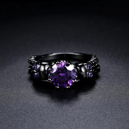 Anillo vintage redondo negro con una piedra preciosa morada